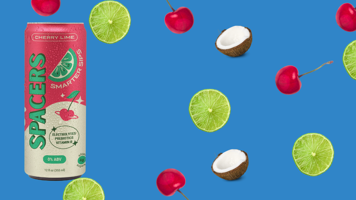 Vibrant blue background featuring fresh cherries, tropical coconuts, and a sleek 12 oz slim can of Spacers Cosmic Cherry Lime. This eye-catching lifestyle image highlights the non-alcoholic beverage’s fruity flavors and tropical vibe, perfect for mindful drinking and sober curious consumers.