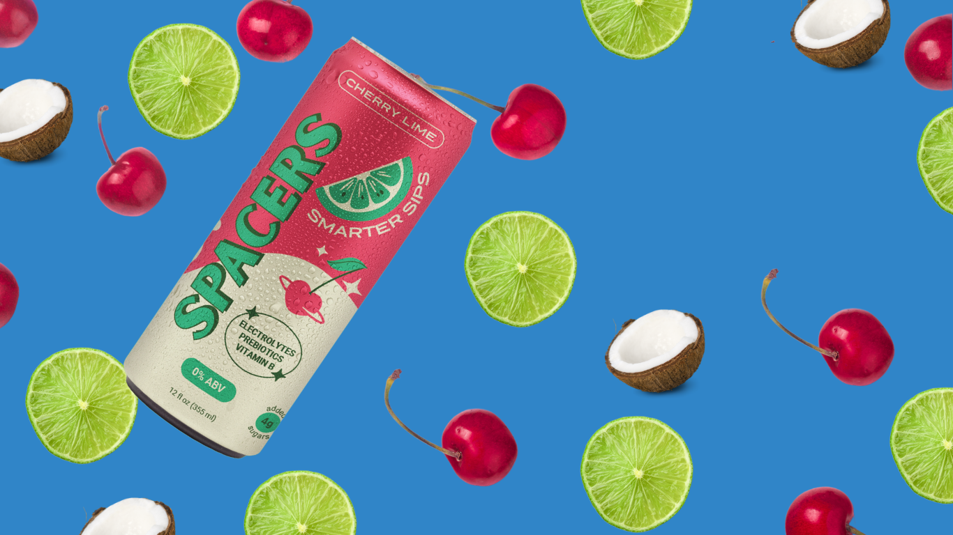 Vibrant blue background featuring fresh cherries, tropical coconuts, and a sleek 12 oz slim can of Spacers Cosmic Cherry Lime. This eye-catching lifestyle image highlights the non-alcoholic beverage’s fruity flavors and tropical vibe, perfect for mindful drinking and sober curious consumers.